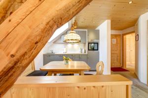una cucina e una sala da pranzo con tavolo in legno di Appartement Zentral de Luxe by A-Appartments a Brand