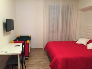 a bedroom with a bed and a table and a desk at Itaka in LʼAquila