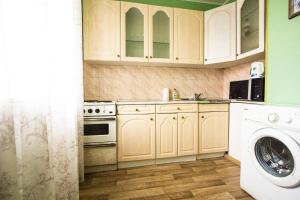 a kitchen with white cabinets and a washing machine at ApartLux on Prospekt Vernadskogo in Moscow