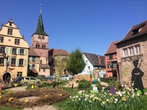a town with a statue of a woman in a garden at camping Le Médiéval in Turckheim +9 photos