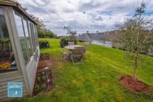 a garden with a table and chairs in a yard at The Garden Studios in Budleigh Salterton