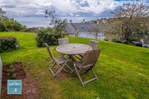 a wooden table and two chairs in a yard at The Garden Studios in Budleigh Salterton