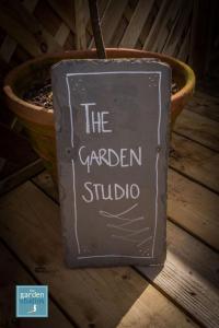 a sign that reads the garden studio in front of a planter at The Garden Studios in Budleigh Salterton