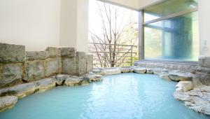 a swimming pool in a room with a rock wall at Hotel Laforet Nasu in Nasu