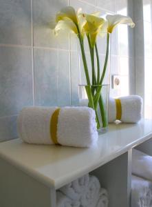 a vase with yellow flowers on a shelf with towels at Apartments Kut in Vis +23 photos