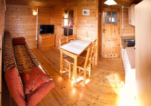 a room with a table in a log cabin at Domki Rybka in Sarbinowo