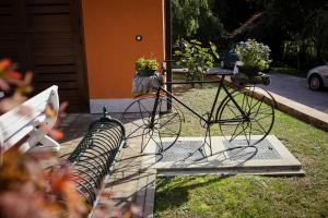 uma bicicleta estacionada ao lado de um banco com vasos de plantas em Apartment Čarolija em Slakovec