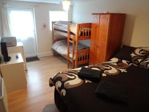a small room with a bed and a bunk bed at Travellers Rest Motel in Ingoldmells