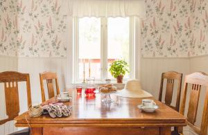 Un comedor con una mesa de madera y una ventana. en Bosgårdens Cottages, en Broddetorp