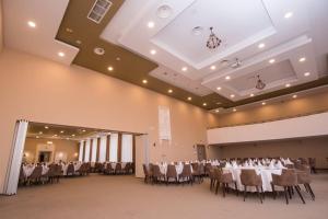 a banquet hall with tables and chairs in a room at Miznah Hotels & Resorts in Bačka Topola