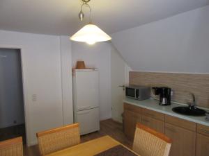 cocina con nevera blanca y fregadero en Ferienapartment Meiss, en Erdeborn