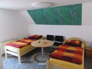 a room with two beds and a table with chairs at Ferienapartment Meiss in Erdeborn