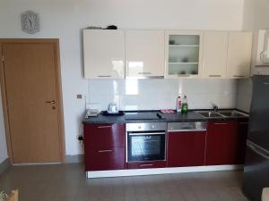 a kitchen with red cabinets and a stove top oven at Holiday home >Nikola< Brijesta in Brijesta