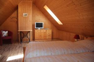 a bedroom with a bed and a tv in a attic at Ferienwohnung Weidengrund Burg Kauper in Byhleguhre-Byhlen