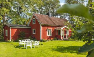 una casa roja con una mesa de picnic delante de ella en Bosgårdens Cottages, en Broddetorp 11 fotos más