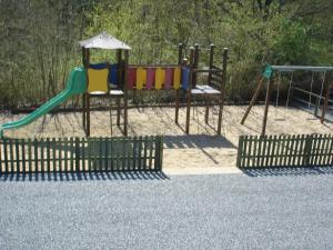 a playground with two swings and a slide at Puy Rond Camping in Bressuire