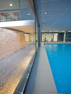 - une piscine dans un bâtiment doté d'une grande piscine bleue dans l'établissement Lagrange Apart’Hotel Strasbourg Wilson, à Strasbourg