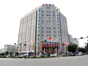 a large building on the corner of a street at GreenTree Inn Shandong Zaozhuang Shanting JinkeGuoji Yijiaren Business Hotel in Zhaozhuang