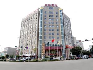 a large building on the corner of a street at GreenTree Inn Shandong Zaozhuang Shanting JinkeGuoji Yijiaren Business Hotel in Zaozhuang