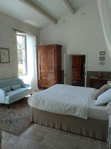 a bedroom with a bed and a couch and a window at Le Moulin de la Borderie in Saint-Pierre-dʼOléron