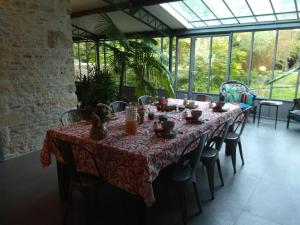a table in a conservatory with a red table cloth at Le Moulin de la Borderie in Saint-Pierre-dʼOléron