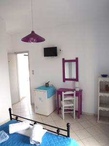 - une chambre avec un lit, une table et un miroir dans l'établissement ELEFTHERIA rooms, à Livadiá