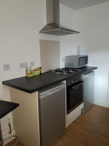 a kitchen with a stove and a microwave at AA Apartment Westoe Road in South Shields