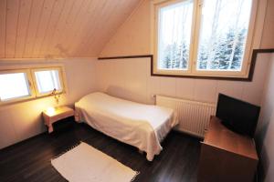 a small bedroom with a bed and a television at Villa Haapaniemi in Iisalmi