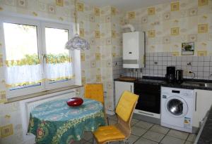 a kitchen with a table and a washing machine at Schwalbennest in Geesthacht