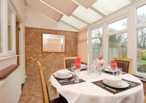 a dining room with a table with chairs and windows at Large Cosy House Ideal for Corporate Lets in Andover