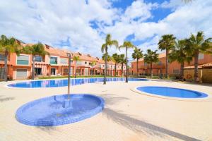 a courtyard with two pools and palm trees at Palm Villa Albufeira in Albufeira