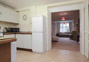 a kitchen with a white refrigerator and a living room at Large Cosy House Ideal for Corporate Lets in Andover +11 photos