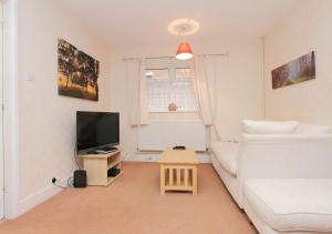 a living room with a white couch and a tv at Large Cosy House Ideal for Corporate Lets in Andover