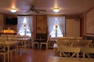 a dining room with tables and chairs and windows at Hotell Björnidet in Torsby