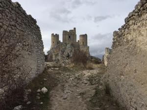a castle sitting on top of a rocky mountain at Itaka in LʼAquila