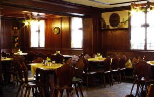 - une salle à manger avec des tables, des chaises et des fenêtres dans l'établissement Traditionsgasthof Grüner Baum, à Bad Staffelstein