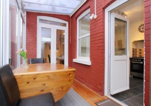 an office with a wooden table and a red brick wall at Lovely Victorian House in Andover