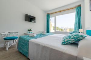 a bedroom with a bed and a large window at Panorama in Port de Pollensa