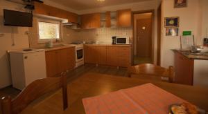 a small kitchen with wooden cabinets and a table and a table sidx sidx at Apartment House Sumrak in Bizeljsko