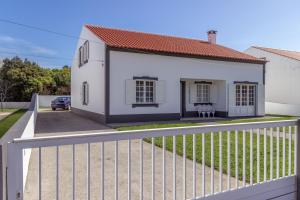 a white house with a white fence at Casa do Norte (AL) in Biscoitos