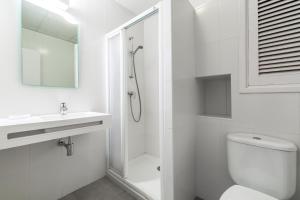 a white bathroom with a shower and a toilet at Panorama in Port de Pollensa