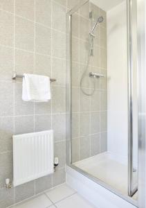 a bathroom with a shower with a glass door at ShortstayMK Campbell Park serviced houses, with free superfast wi-fi, parking, Sky sports and movies in Milton Keynes