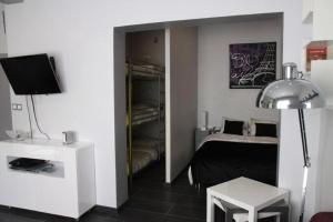 Habitación con 1 dormitorio con 1 cama y TV. en Appartement Les Confidences, en Le Touquet-Paris-Plage