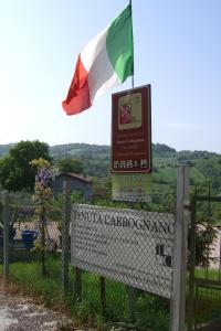 un panneau portant un drapeau au-dessus d'une clôture dans l'établissement Tenuta Carbognano, à Gemmano