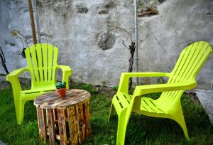 ヴェルバーニアにあるCasina dello Zioの緑の椅子2脚、切り株の上に植物を置いたテーブル