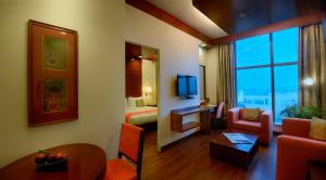 a hotel room with a living room with a large window at Elevate by TreeHouse in Bhiwadi