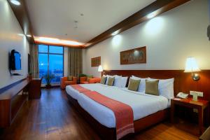 a hotel room with a large bed and a television at Elevate by TreeHouse in Bhiwadi