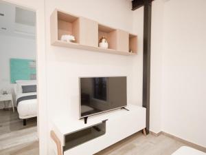 salon z telewizorem na białej ścianie w obiekcie Apartamento nuevo y de lujo en puerta del sol w Madrycie
