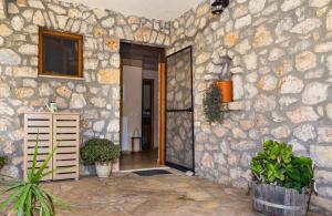 a building with a stone wall with a door at Nireas : Stone Villa in Zakynthos