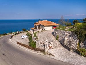 a house with a car parked on the side of a road at Nireas : Stone Villa in Zakynthos